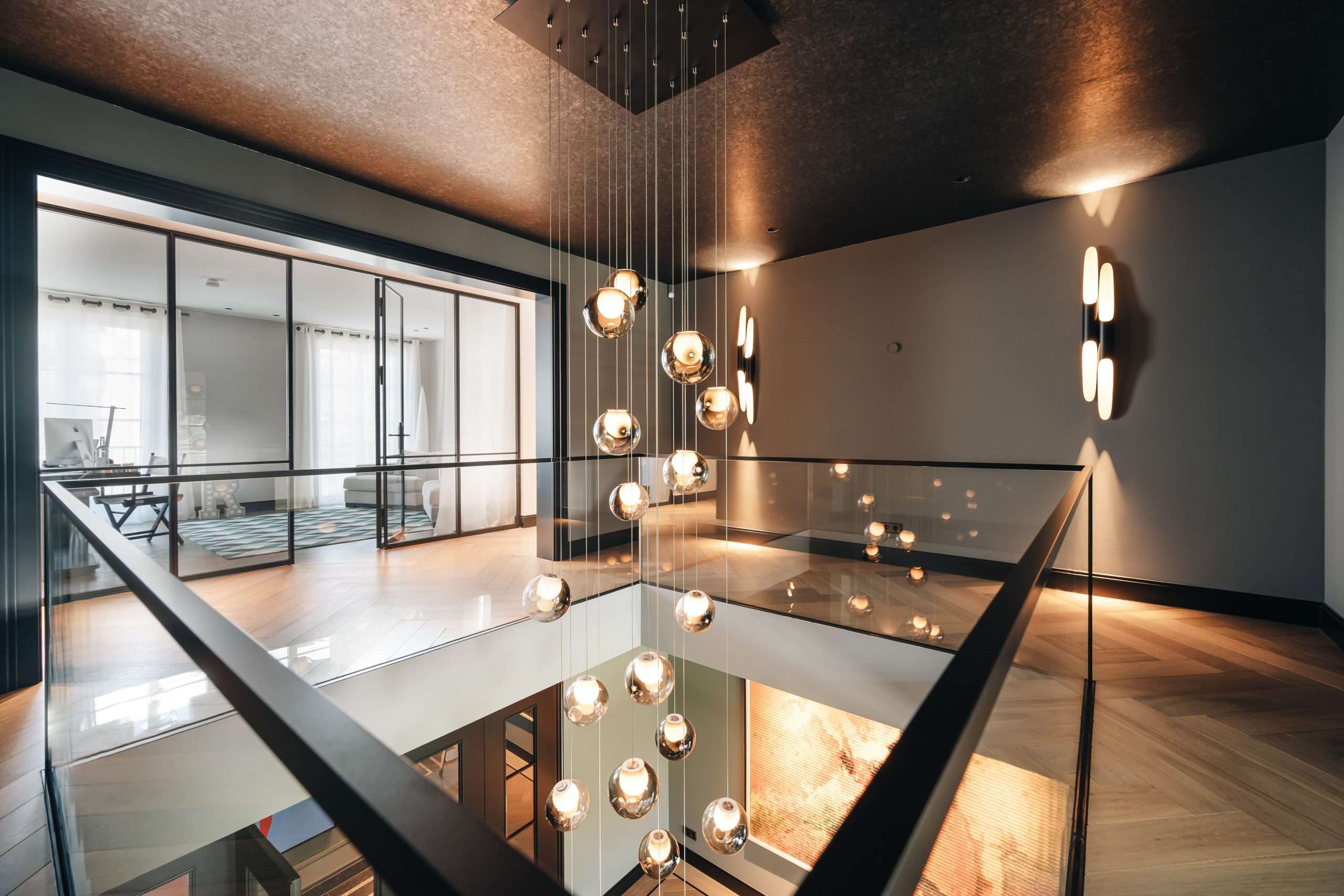 Interior Design. Leuchtkugeln hängen in einer mehrstöckingen Galerie in Düsseldorfer Anwesen.