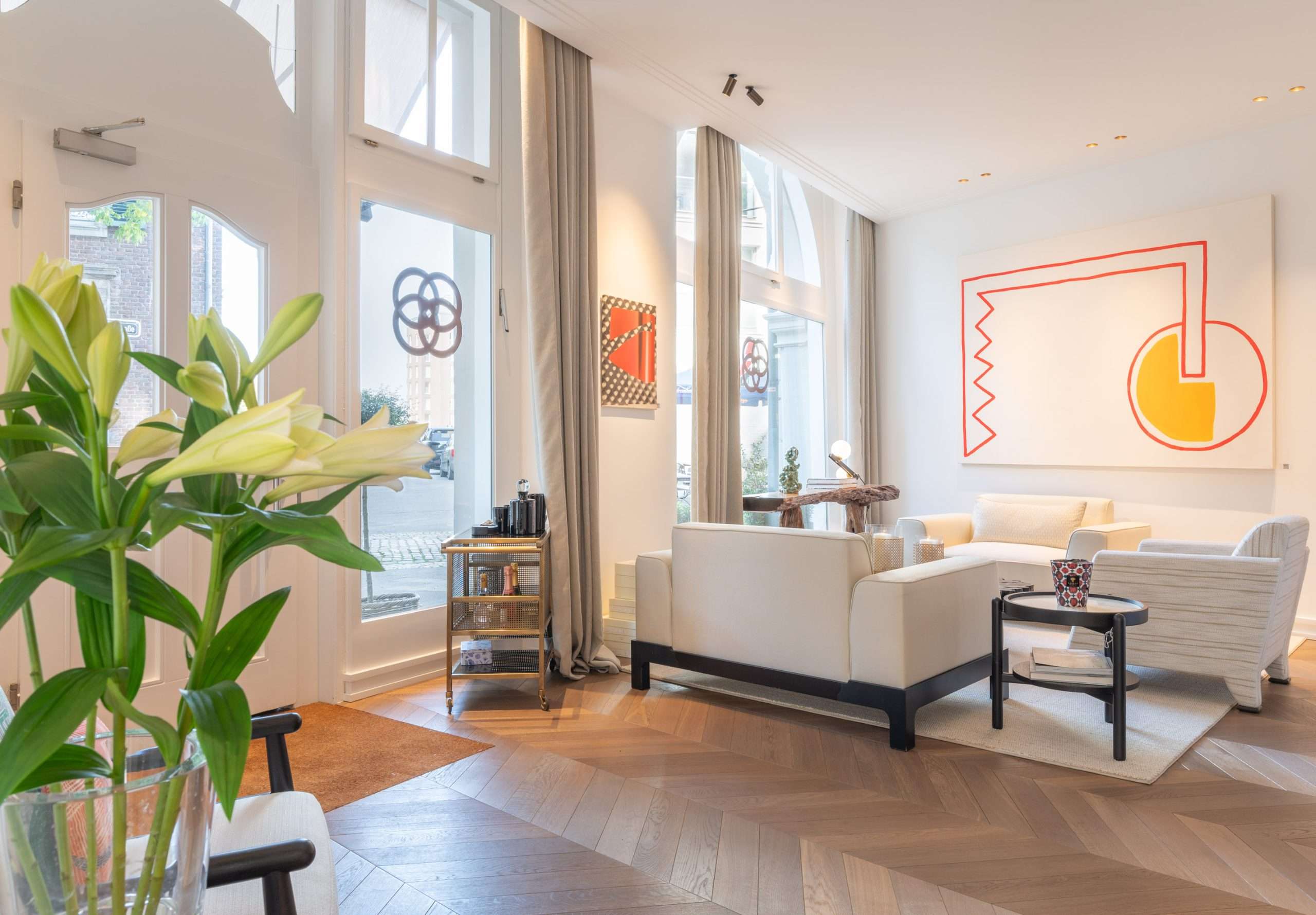 Ein gemütliches Wohnzimmer mit einer warmen Farbpalette und stilvoller Einrichtung lädt zum Entspannen ein.