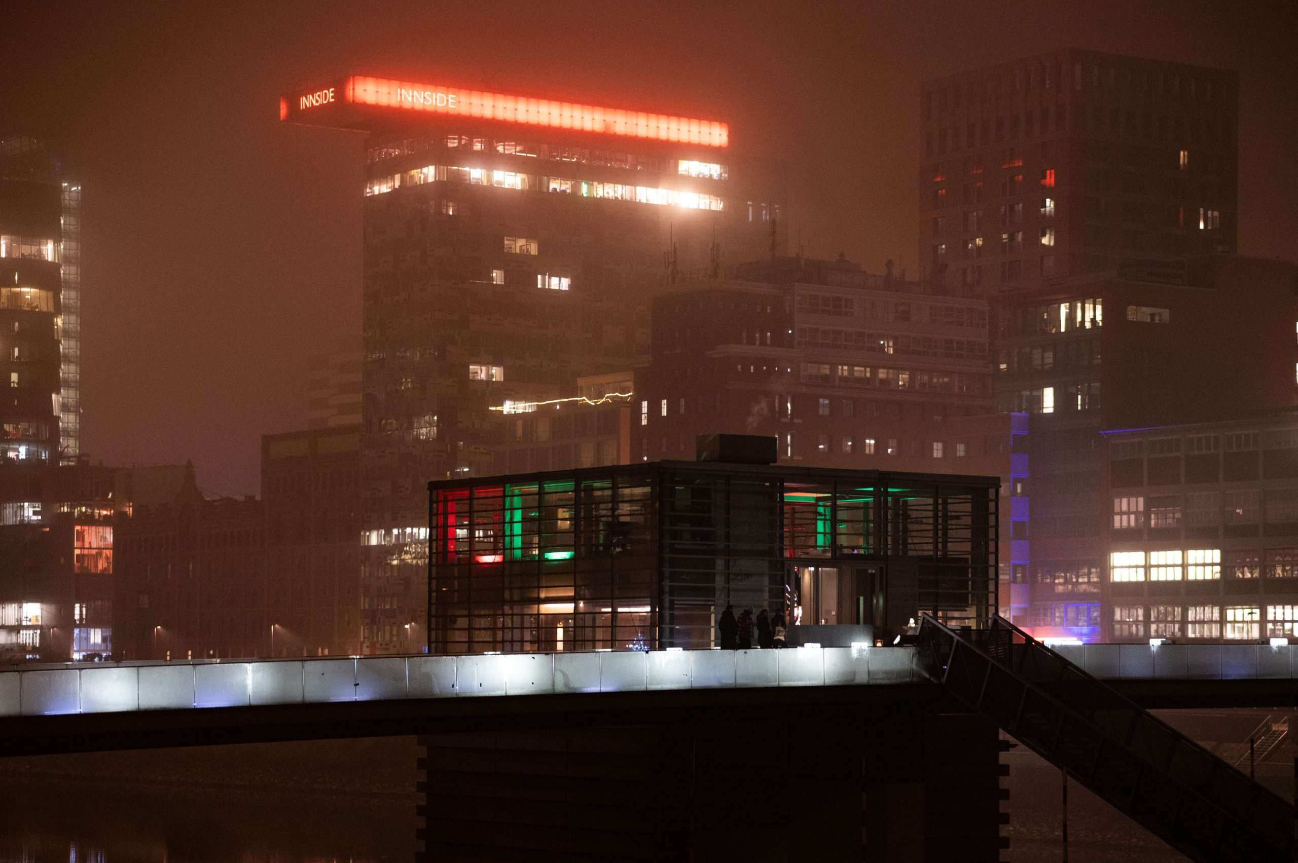 Medienhafen Architektur-2 Medienhafen Düsseldorf Architektur bei Nacht. Im Hintergrund im nebel ist das Colorium sichtbar. Vorne ist das Restaurant Lido an der Brücke.